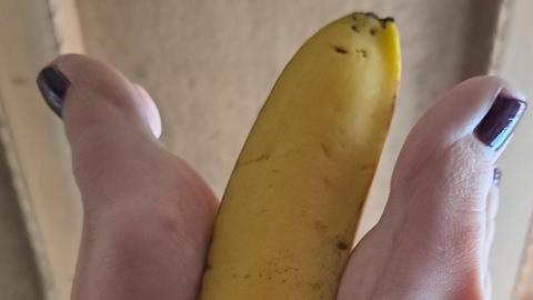 Meine Füße spielen mit einer Banane